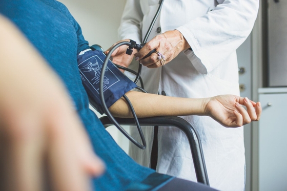 A doctor measuring a patient's blood pressure using a sphygmomanometer, ensuring their health is monitored.