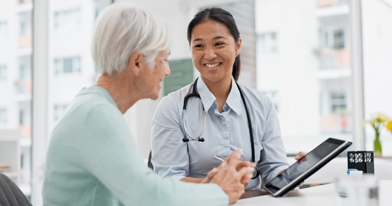 Doctor and elderly patient with digital health report 