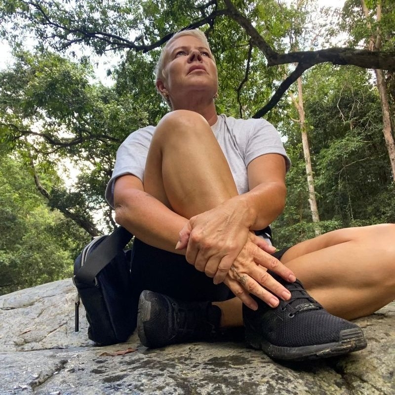Emma, sitting in nature on a rock