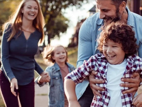 A mother, father, son and daughter playing outside